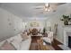 Open-concept living room with views of the dining area, wood floors, and a cozy fireplace at 4936 Liverpool Ln, Raleigh, NC 27604