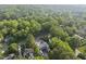 An aerial shot showcases the property surrounded by mature trees, highlighting the lush landscape of the area at 516 Transylvania Ave, Raleigh, NC 27609