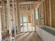 New home bathroom under construction featuring wood beams, plumbing and a freestanding tub at 516 Transylvania Ave, Raleigh, NC 27609