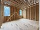 New home bedroom under construction featuring wooden beams, multiple windows and plywood flooring materials at 516 Transylvania Ave, Raleigh, NC 27609