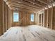 New home bedroom under construction featuring wooden beams, multiple windows, and plywood flooring at 516 Transylvania Ave, Raleigh, NC 27609