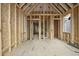 Unfinished living room featuring wood framing, unfinished walls, and natural lighting at 516 Transylvania Ave, Raleigh, NC 27609