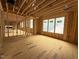 New home living room under construction showcasing wood beam framing, multiple windows and an open concept design at 516 Transylvania Ave, Raleigh, NC 27609