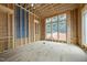 Under construction living room with wood framing and large windows offering views of the backyard at 516 Transylvania Ave, Raleigh, NC 27609