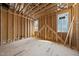 Under-construction room with wood framing, multiple windows, and exposed beams, highlighting the structural phase of development at 516 Transylvania Ave, Raleigh, NC 27609