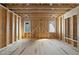 Under-construction room with exposed beams, wood framing, and natural light from two windows, showcasing the structural build at 516 Transylvania Ave, Raleigh, NC 27609
