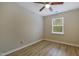 Bedroom features a ceiling fan, wood-look flooring, and a window to the backyard at 5329 Big Bass Dr, Raleigh, NC 27610