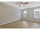 This bedroom features wood-look flooring, a ceiling fan, and two windows for natural light at 5329 Big Bass Dr, Raleigh, NC 27610