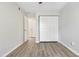 A bedroom with wood floors, a closet, and views into an adjoining room at 5329 Big Bass Dr, Raleigh, NC 27610