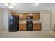 Efficient kitchen with ample cabinet space, black appliances, and neutral tile flooring at 5329 Big Bass Dr, Raleigh, NC 27610