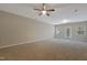 Spacious carpeted living room featuring a ceiling fan and a glass door leading to the exterior at 5329 Big Bass Dr, Raleigh, NC 27610