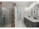 Modern bathroom with glass-enclosed shower, double vanity with black hardware, and neutral finishes at 621 Bon Air Ave, Durham, NC 27704