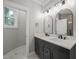 Modern bathroom with double vanity, black hardware, modern lighting, and natural light from a window at 621 Bon Air Ave, Durham, NC 27704