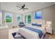 Beautifully staged bedroom with three windows, blue accents, fan, and natural lighting at 621 Bon Air Ave, Durham, NC 27704