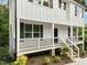 Side view of a white home featuring a cozy porch, wooden stairs, and thoughtfully landscaped garden at 621 Bon Air Ave, Durham, NC 27704