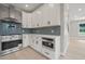 Modern kitchen featuring white cabinets, stainless steel appliances, and blue backsplash at 621 Bon Air Ave, Durham, NC 27704