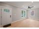 Well-lit living room with hardwood floors, a modern ceiling fan, and a bright white door at 621 Bon Air Ave, Durham, NC 27704