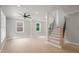 Living room with hardwood floors, multiple windows, ceiling fan and staircase with black metal spindles at 621 Bon Air Ave, Durham, NC 27704