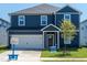 Charming blue two-story home with a well-manicured lawn and a one car garage at 630 White Birch Ln, Angier, NC 27501