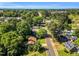 An aerial view shows the neighborhood with a well-maintained streetscape lined with mature trees and lush greenery at 704 N Orange Ave, Dunn, NC 28334