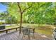 Cozy wooden deck shaded by mature trees, perfect for outdoor dining or relaxation with a view of the backyard at 704 N Orange Ave, Dunn, NC 28334