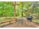 Cozy outdoor deck with a grill and seating, surrounded by trees, perfect for enjoying outdoor dining at 704 N Orange Ave, Dunn, NC 28334