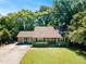 Beautiful single-story home with a well-manicured lawn, mature trees, and a welcoming entrance, perfect for families at 704 N Orange Ave, Dunn, NC 28334