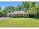 Charming single-story home featuring a well-manicured lawn and inviting front entrance, complemented by lush greenery at 704 N Orange Ave, Dunn, NC 28334