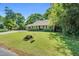 Well-manicured lawn enhances the curb appeal of this home with its attractive landscaping and mature trees at 704 N Orange Ave, Dunn, NC 28334
