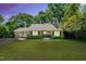 Inviting single-story home at twilight, showcasing a well-kept lawn and an illuminated, welcoming front entrance at 704 N Orange Ave, Dunn, NC 28334