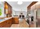 Traditional kitchen featuring ample wood cabinetry, stainless steel appliances, and tile flooring with open dining area at 704 N Orange Ave, Dunn, NC 28334