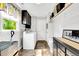 Bright laundry room features a washer and dryer, storage cabinets and shelving, and a window for natural light at 704 N Orange Ave, Dunn, NC 28334