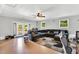 Large living room with a plush leather sectional, windows, ceiling fan, and stylish rug, perfect for entertaining at 704 N Orange Ave, Dunn, NC 28334