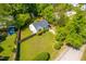Aerial view of a well-maintained home with lush green lawns, privacy fence, and mature trees at 705 Hartford Rd, Raleigh, NC 27610