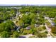 An aerial view of a home nestled in a tree-filled neighborhood with a distant city skyline at 705 Hartford Rd, Raleigh, NC 27610