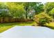 Expansive backyard features a patio area, lush green grass, and mature trees at 705 Hartford Rd, Raleigh, NC 27610