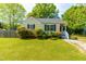 Inviting single-story home with blue shutters, lush green lawn and landscaping at 705 Hartford Rd, Raleigh, NC 27610