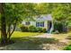 Charming single-story home with blue shutters, green lawn and mature shade trees at 705 Hartford Rd, Raleigh, NC 27610