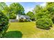 Well-manicured lawn of home with blue shutters and vibrant green foliage at 705 Hartford Rd, Raleigh, NC 27610