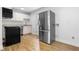 View of kitchen with stainless steel refrigerator, granite counters, and hardwood floors at 705 Hartford Rd, Raleigh, NC 27610