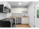 Bright kitchen features white cabinets, stainless steel appliances, and modern countertops at 705 Hartford Rd, Raleigh, NC 27610