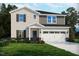 New home featuring a two-car garage, shutters, and landscaping, blending modern comfort and classic design at 728 Deschutes Dr, Garner, NC 27529