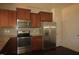 Modern kitchen featuring granite countertops, stainless steel appliances, and wood cabinets at 802 Brier Crossing Loop, Durham, NC 27703
