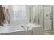 Bright bathroom with bathtub and glass enclosed shower at 803 Footbridge Pl, Cary, NC 27519