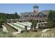 View of a multi-story building with a clock tower, colonnade and well-manicured lawns at 803 Footbridge Pl, Cary, NC 27519