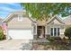 Charming home featuring a two-car garage, stone accents, and beautiful landscaping at 803 Footbridge Pl, Cary, NC 27519