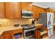 Kitchen with wooden cabinets, stainless steel appliances, and smart storage solutions at 803 Footbridge Pl, Cary, NC 27519