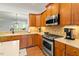 Kitchen with wooden cabinetry, stainless steel appliances, and an island workstation at 803 Footbridge Pl, Cary, NC 27519