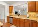 Kitchen with wooden cabinetry, neutral countertops, and stainless steel appliances at 803 Footbridge Pl, Cary, NC 27519