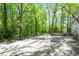 Spacious backyard featuring a basketball hoop, deck, and mature trees at 803 Old Mill Rd, Chapel Hill, NC 27514